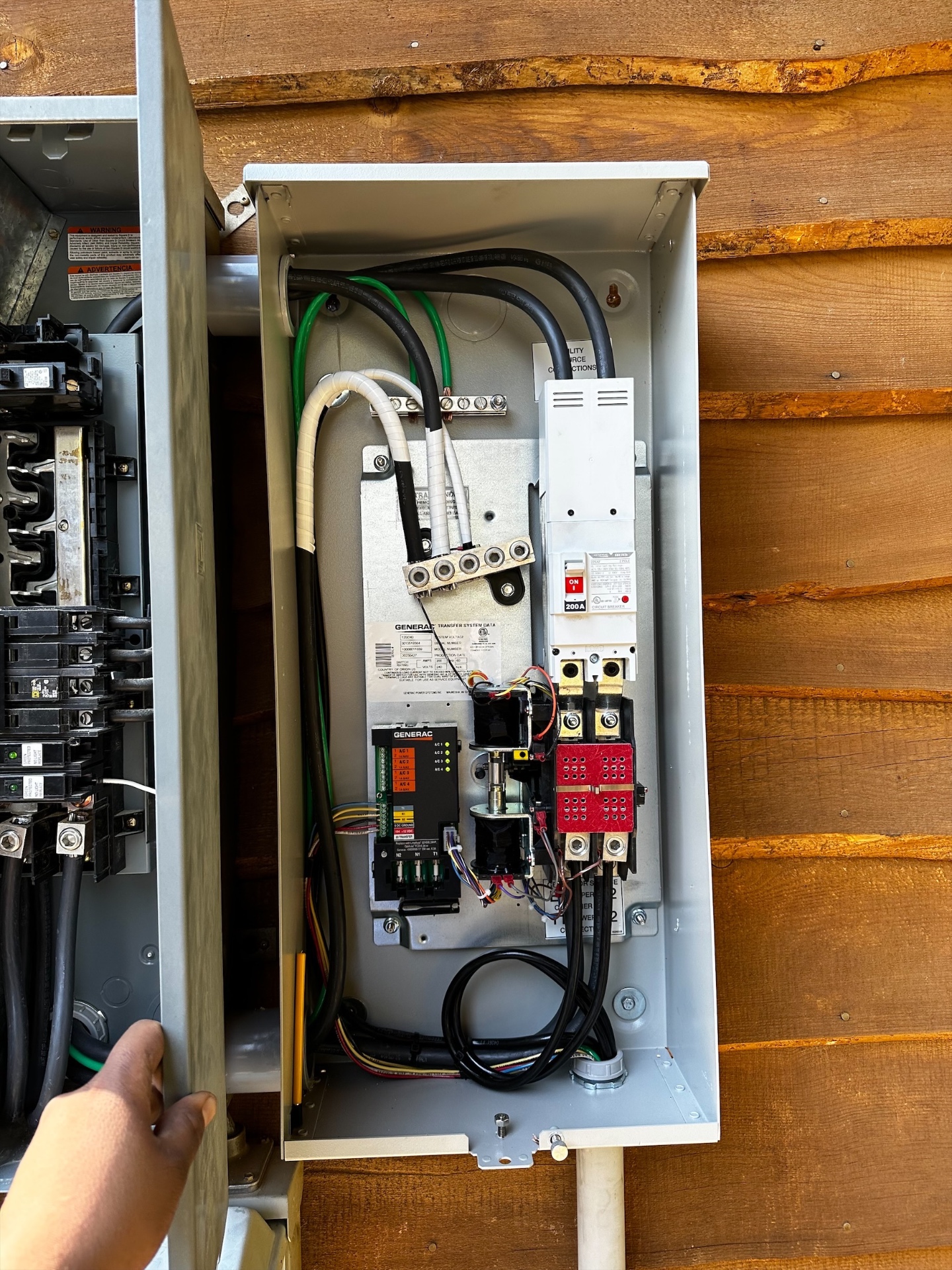 Standby generator on a concrete pad with an automatic transfer switch mounted on the exterior wall